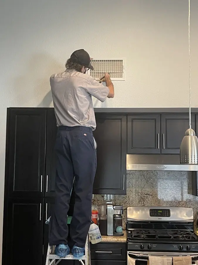Technician inspecting an air vent during HVAC service in Soddy-Daisy